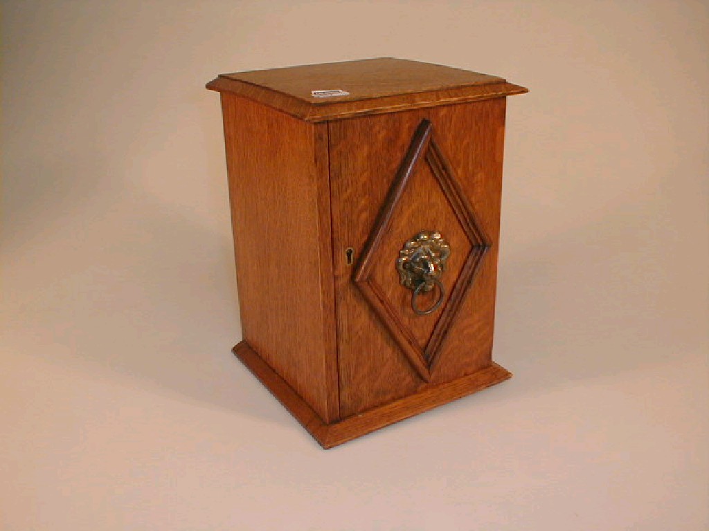 Appraisal: An Edwardian oak smokers cabinet with lion mask handle