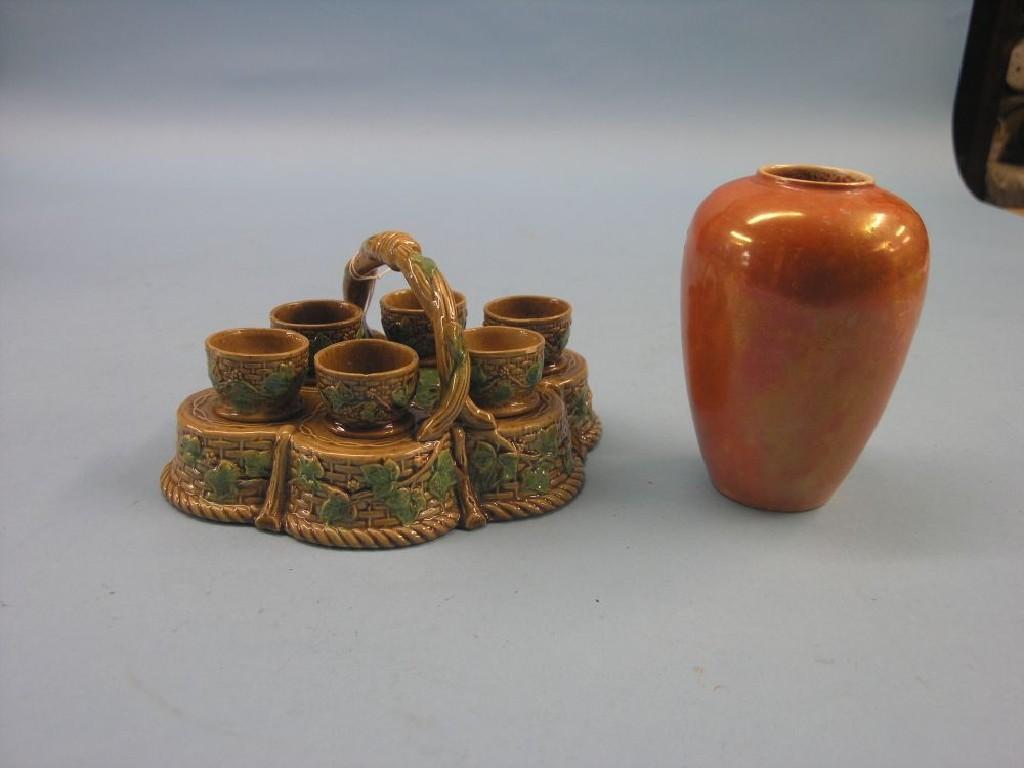 Appraisal: A George Skey earthenware egg cruet including six cups ivy