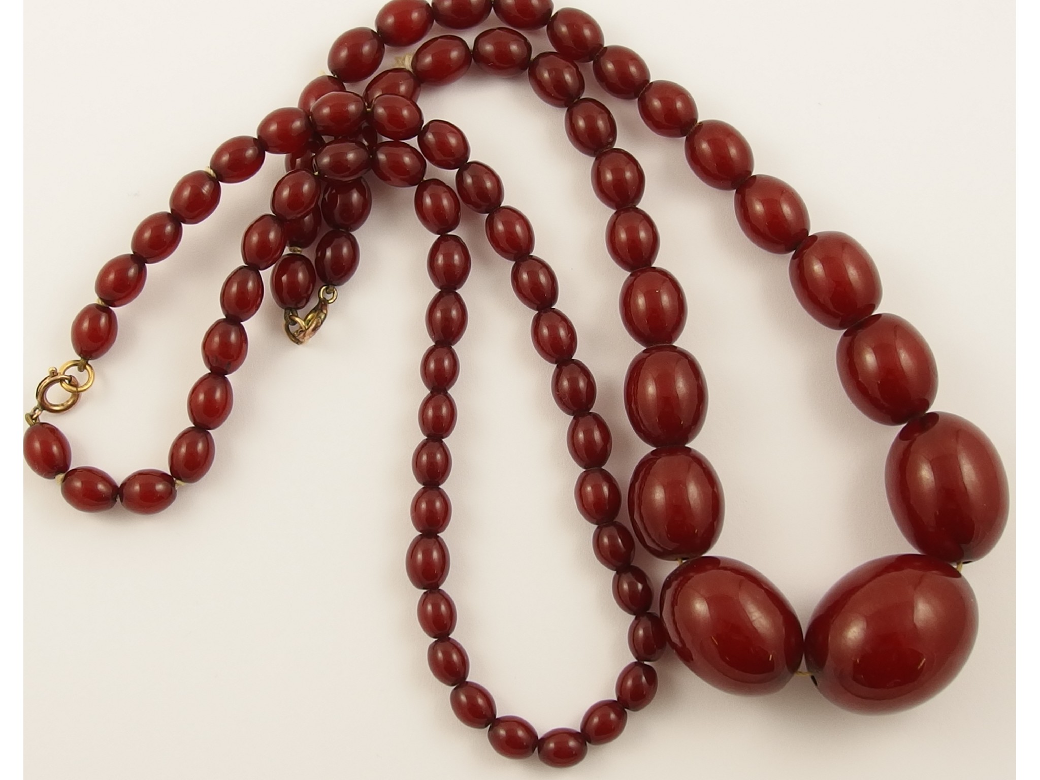 Appraisal: Two cherry amber coloured bead necklaces