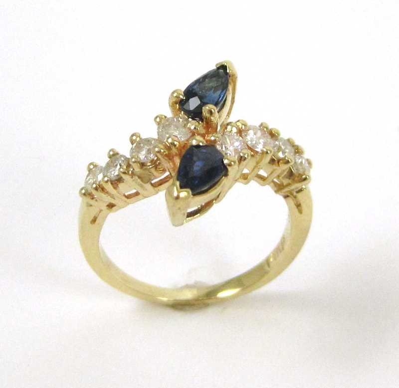 Appraisal: FOURTEEN KARAT GOLD SAPPHIRE AND DIAMOND RING two pear-cut sapphires