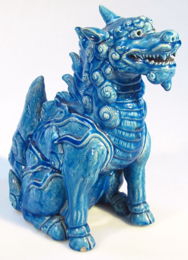 Appraisal: A Chinese earthenware temple dog in seated pose in blue