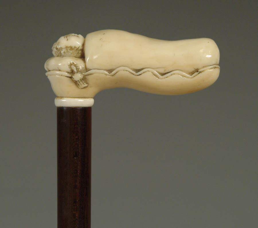 Appraisal: CARVED IVORY SLEEPING CHILD IN BED CANE L-shaped handle has