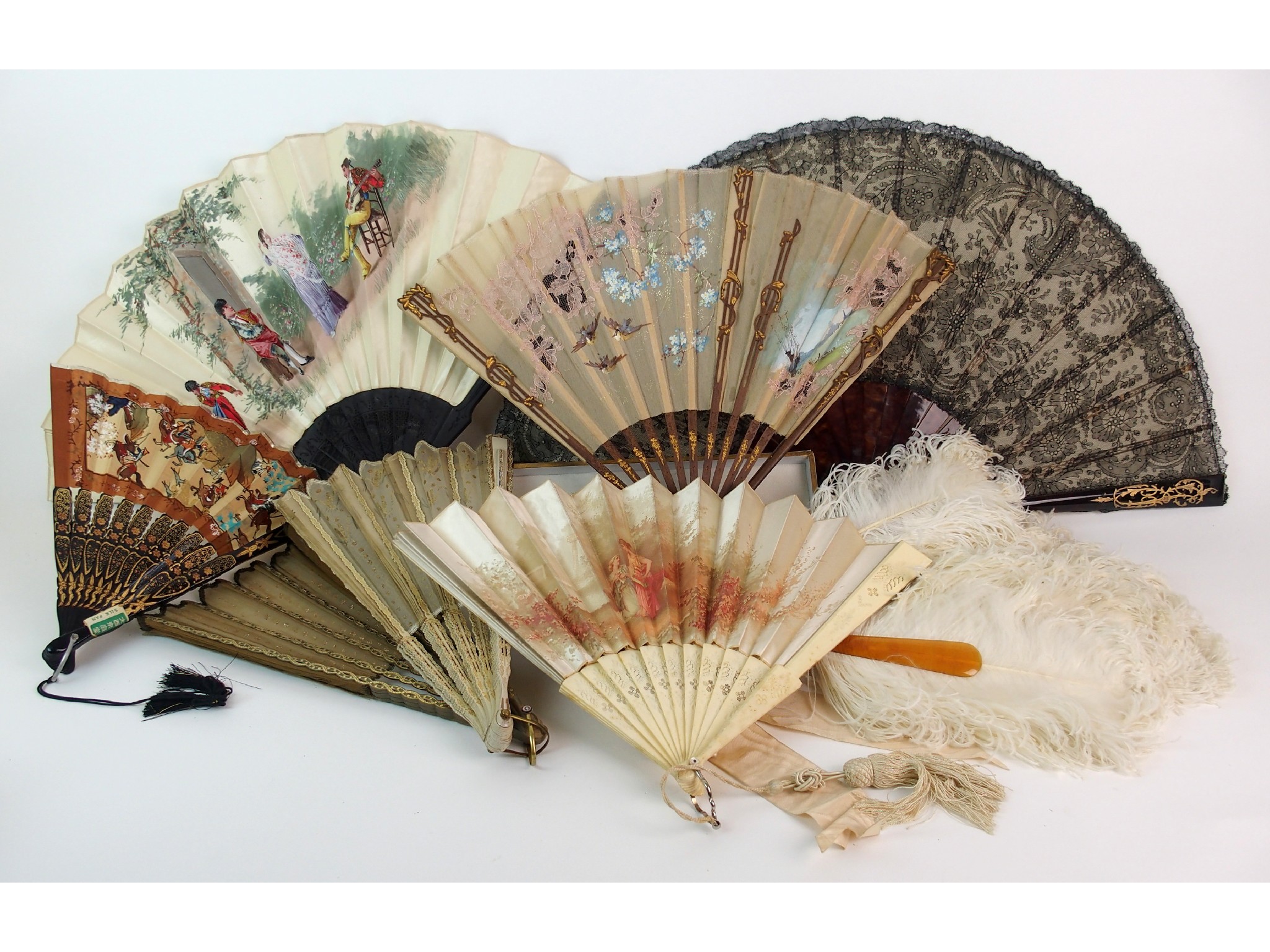 Appraisal: An ostrich feather fanwith four lace fans three paper bladed