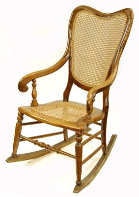 Appraisal: A simulated rosewood rocking chair with a cane back and