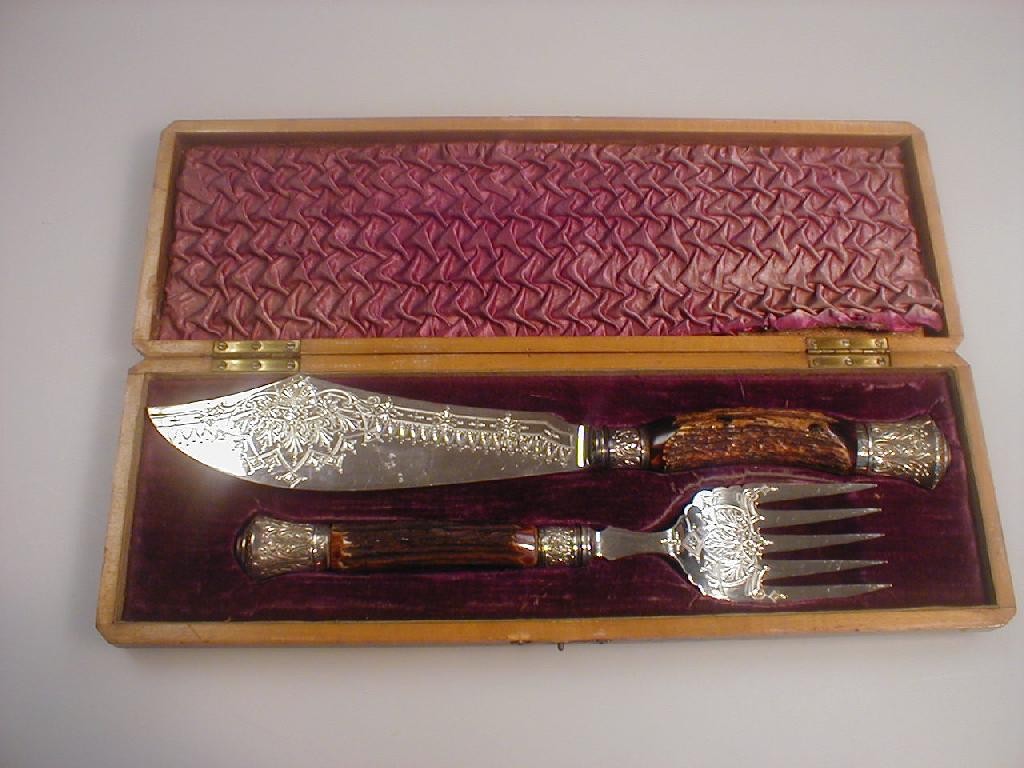 Appraisal: A horn handled silver fish serving set with ornately decorated