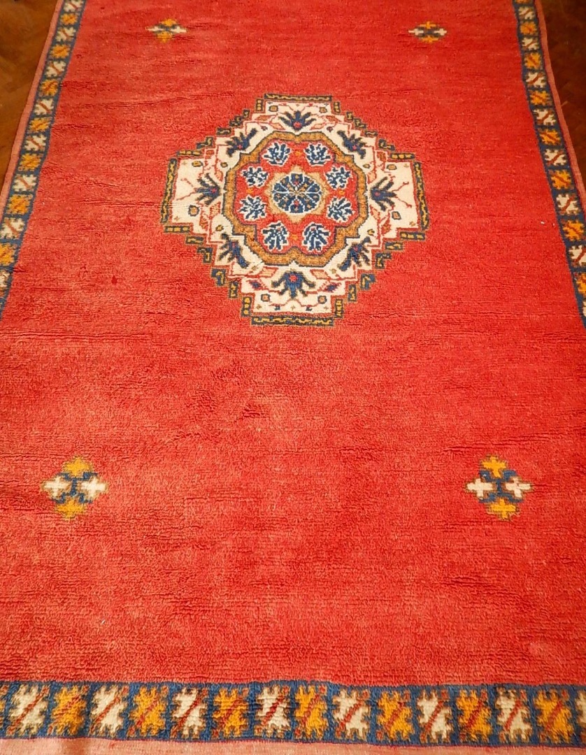 Appraisal: A Moroccan bordered rug with medallion centre on a red