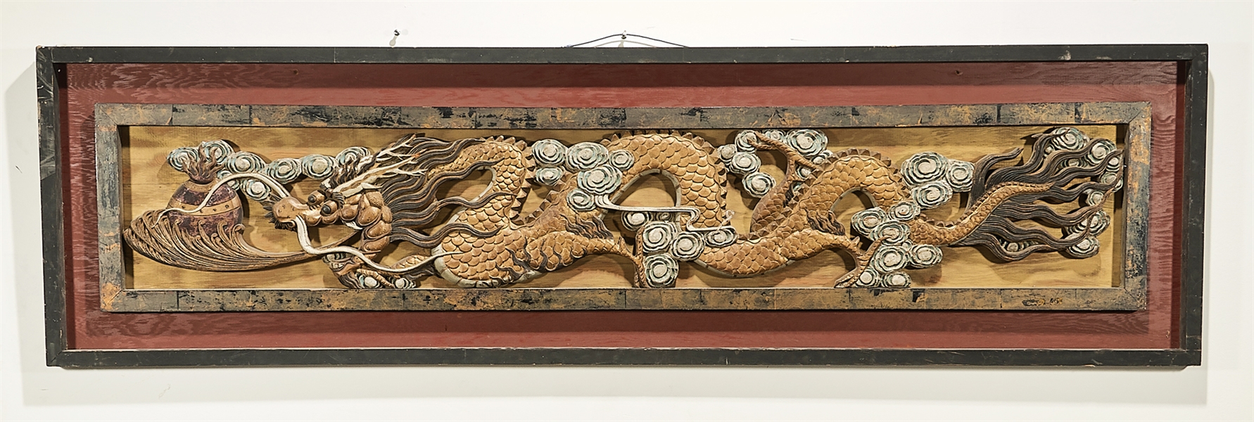 Appraisal: Chinese carved wood framed panel depicting a dragon chasing pearls