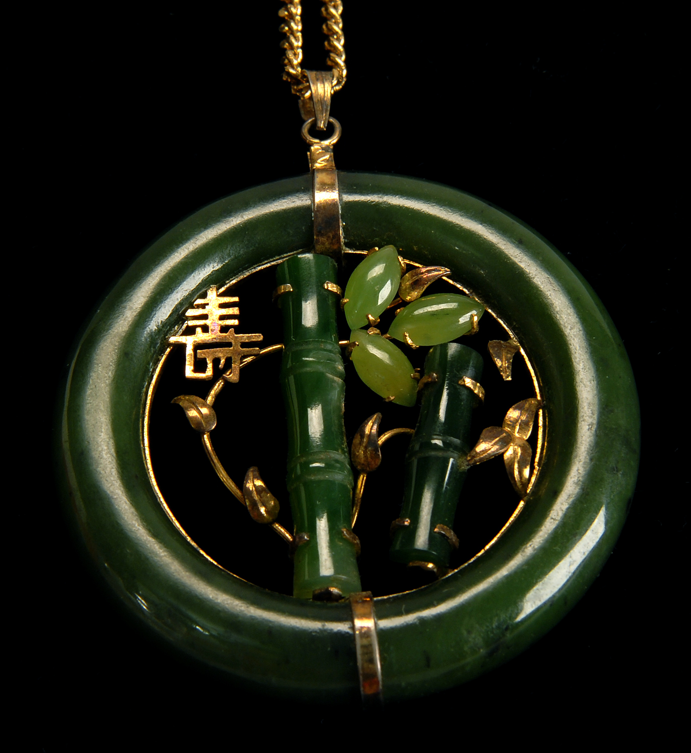 Appraisal: CHINESE JADE PENDANT A spinach jade ring encircles a green