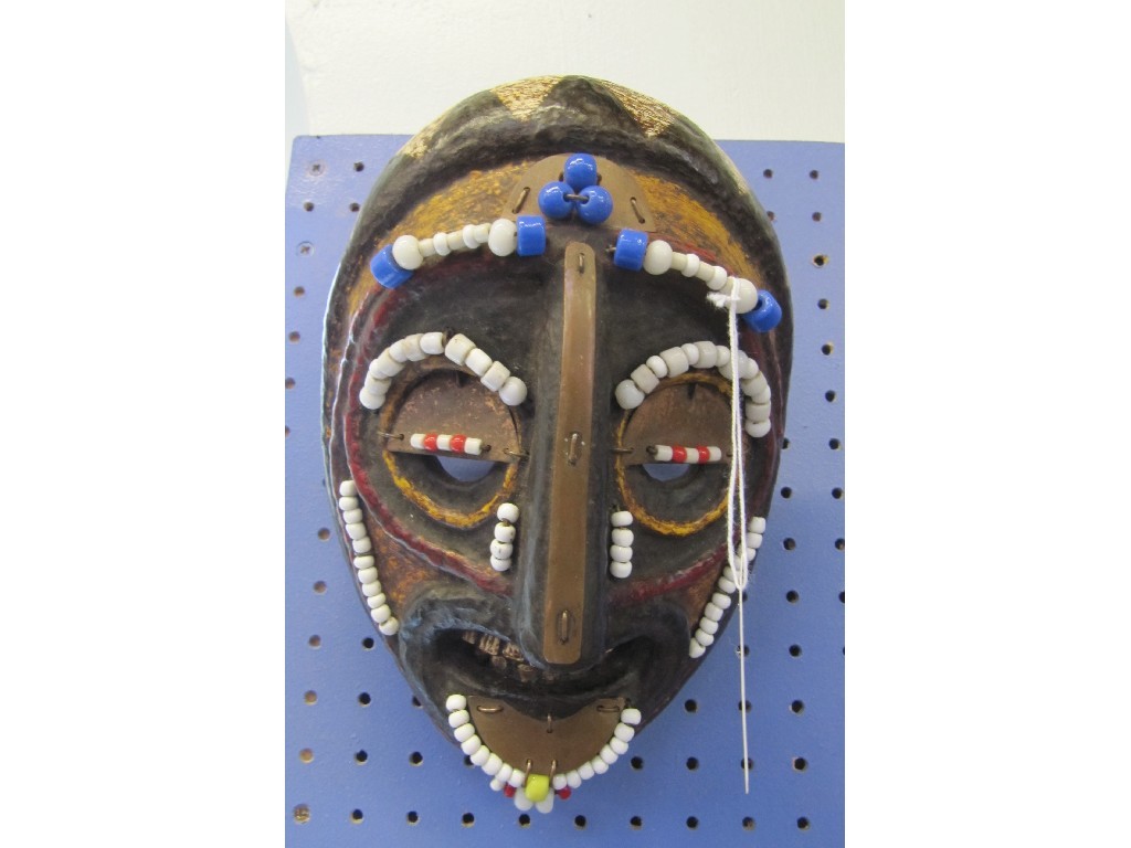 Appraisal: Carved African mask with applied metal decoration