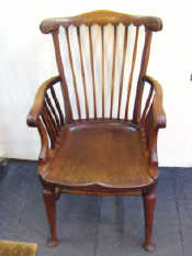 Appraisal: A mahogany captains chair with strut back moulded seat and