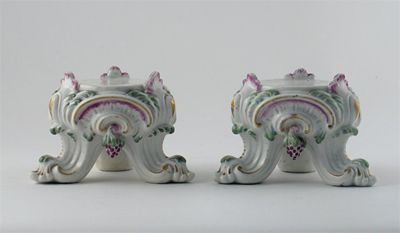 Appraisal: A pair of Chelsea rococo moulded tripod stands hung with