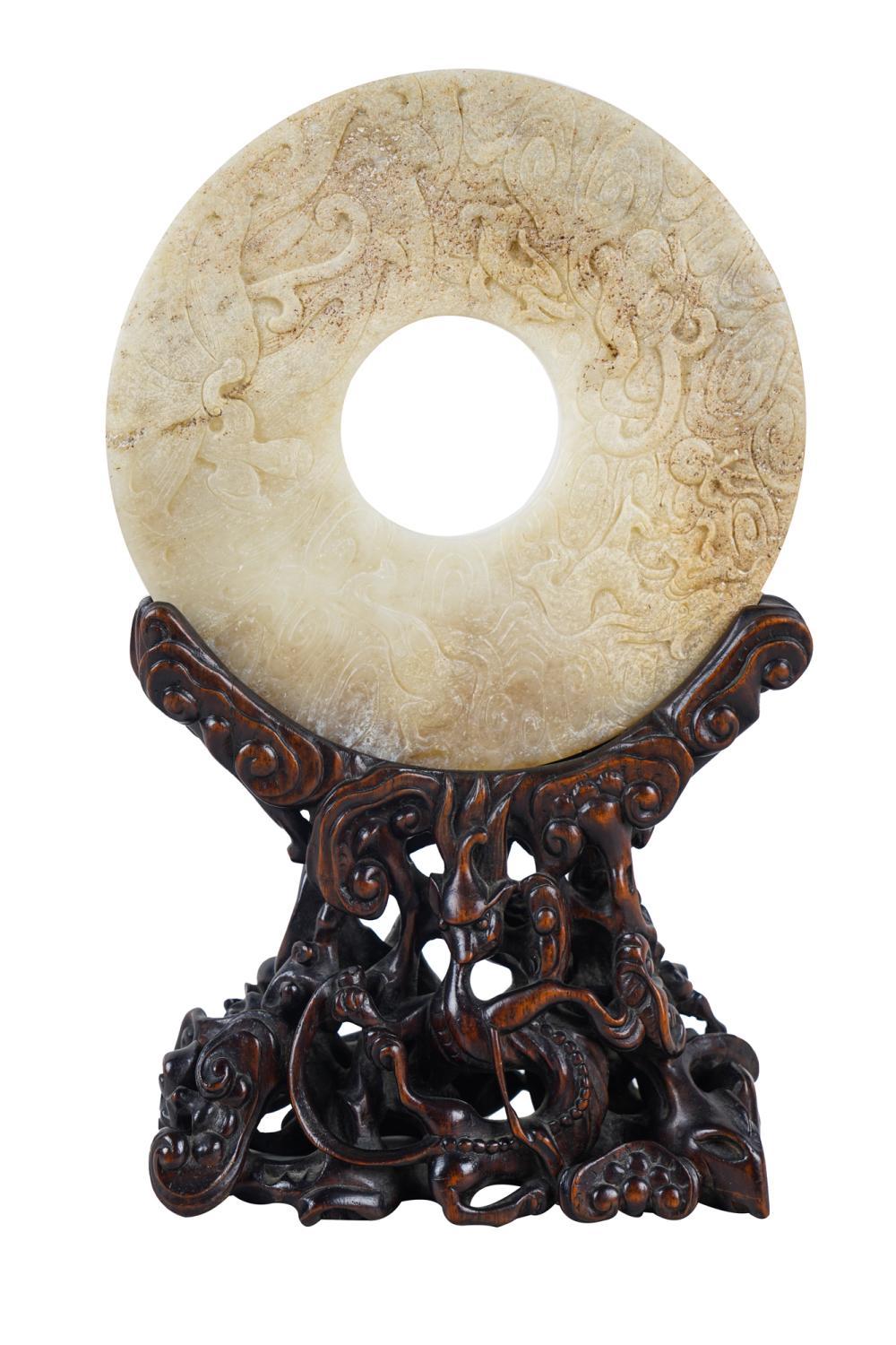 Appraisal: CHINESE JADE BI DISC ON CARVED WOOD BASEthe intricate base