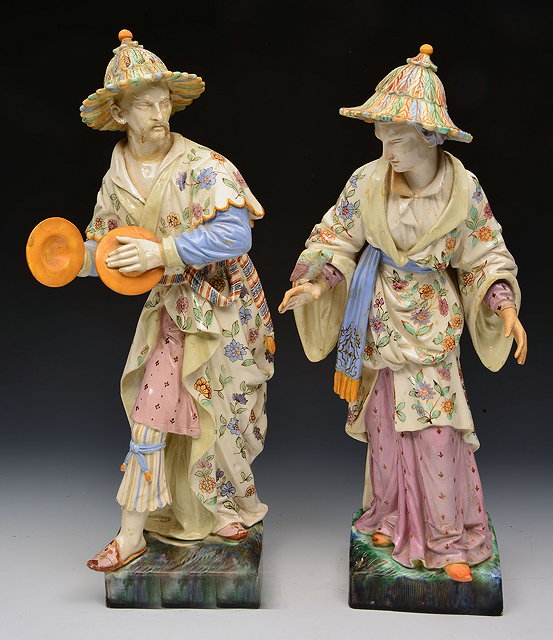 Appraisal: A PAIR OF POLYCHROME POTTERY EASTERN FIGURES each with decorative