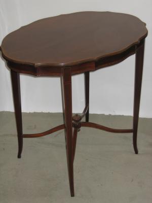 Appraisal: A MAHOGANY OCCASIONAL TABLE of serpentine oval form crossbanded with