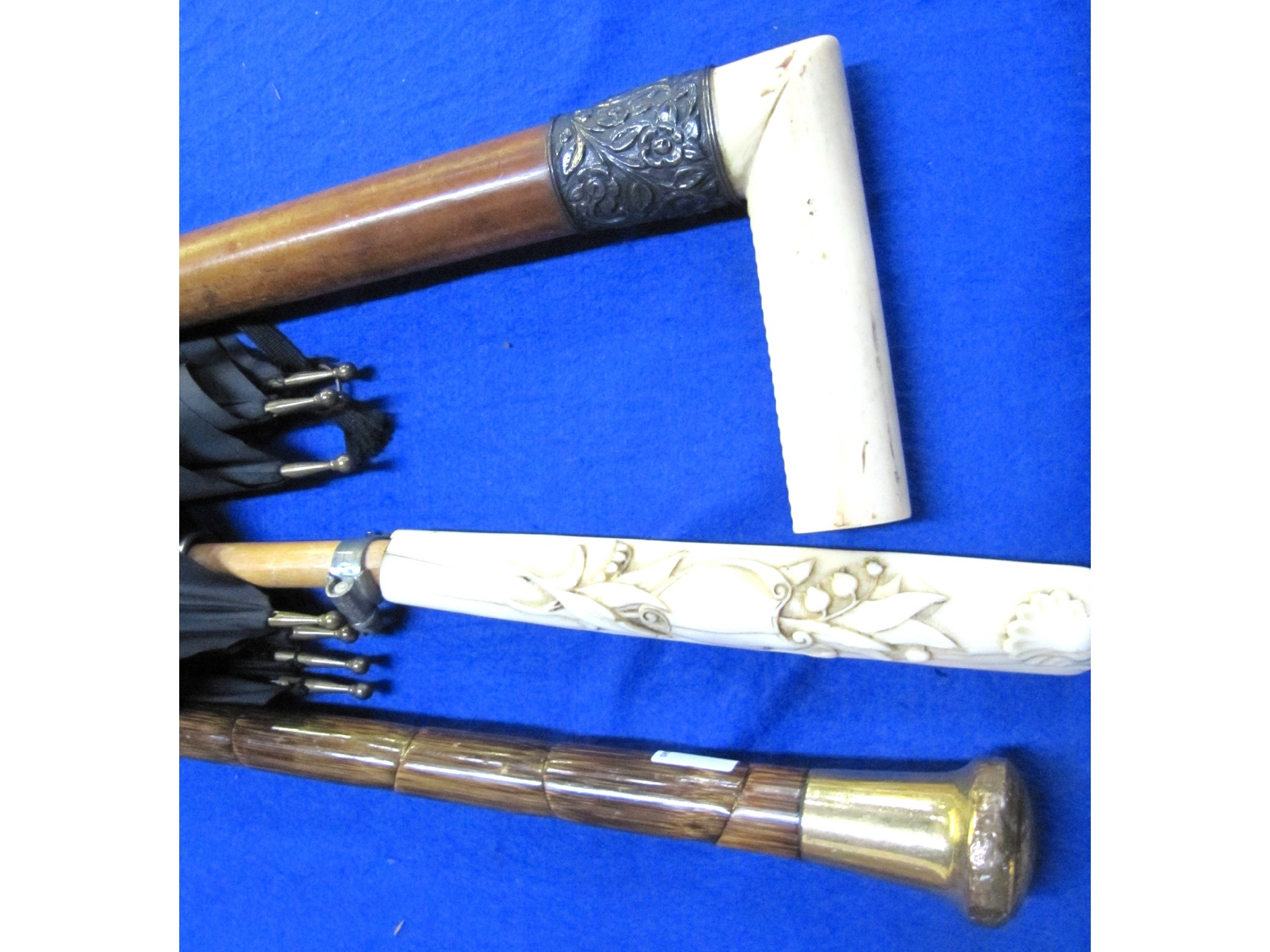 Appraisal: A lot comprising two walking sticks and an umbrella with