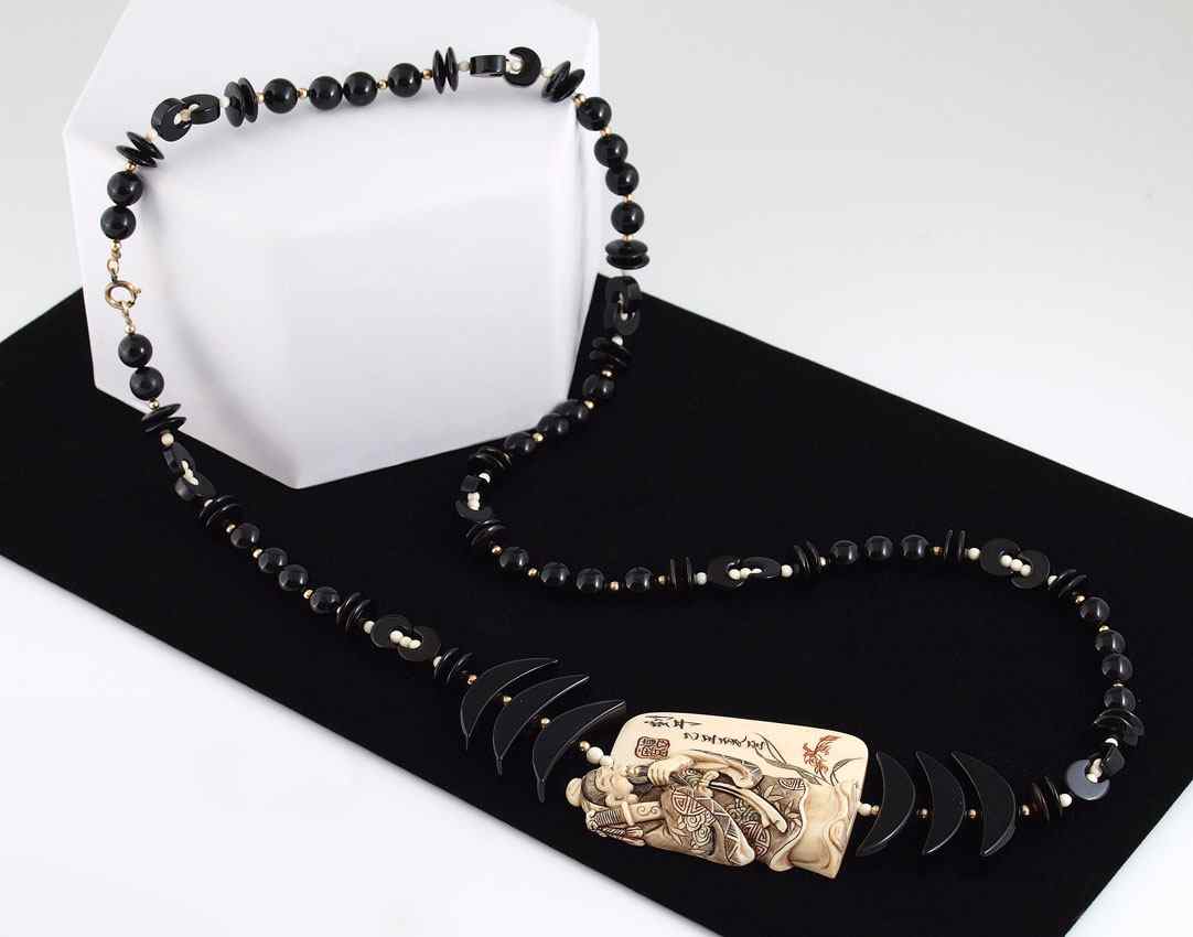 Appraisal: ONYX AND IVORY NECKLACE Necklace of black onyx beads crescent