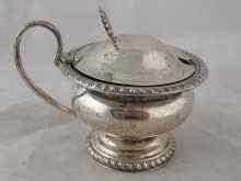 Appraisal: A silver mustard pot with blue glass liner hallmarked Birmingham