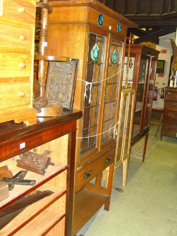 Appraisal: An Edwardian light oak display cabinet enclosed by two coloured