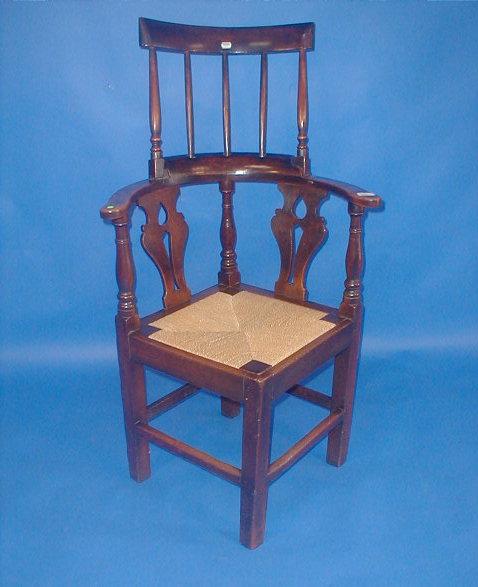 Appraisal: A Georgian elm corner chair with adapted spindle high back