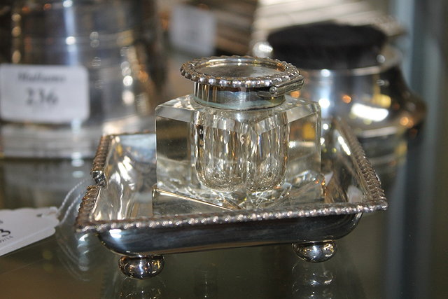 Appraisal: A SILVER INKWELL of lozenge shaped form on bun supports