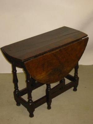 Appraisal: A SMALL OAK GATELEG TABLE the oval plank top on