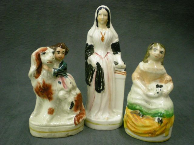 Appraisal: Three Staffordshire figurines including girl holding rabbit sitting on orange