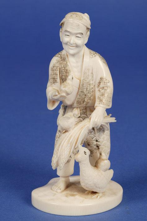 Appraisal: A JAPANESE IVORY OKIMONO of a man with fowl with