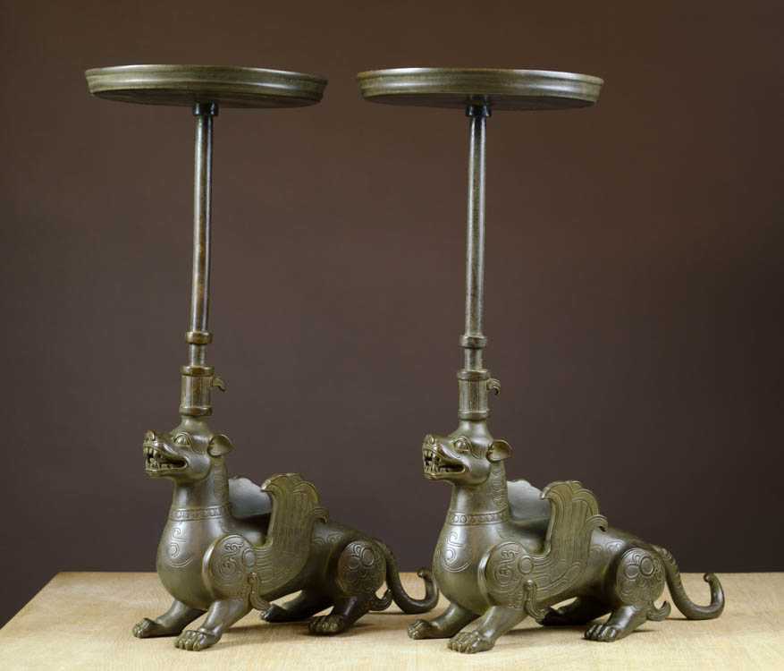 Appraisal: PAIR OF CHINESE FIGURAL BRONZE CANDLESTICKS featuring mythological winged dragon