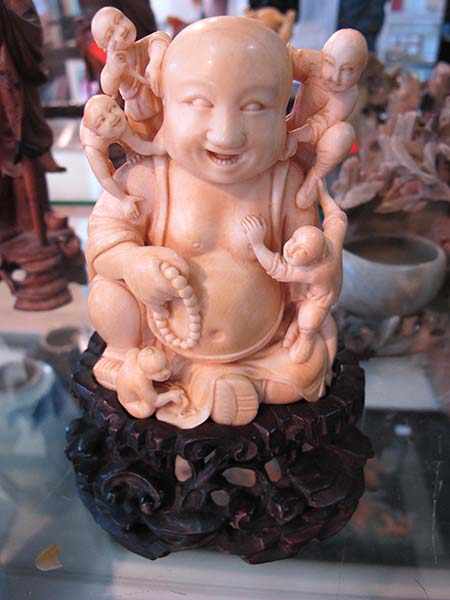 Appraisal: CARVED IVORY FIGURE OF BUDDHA WITH FIVE CLIMBING CHILDREN ON