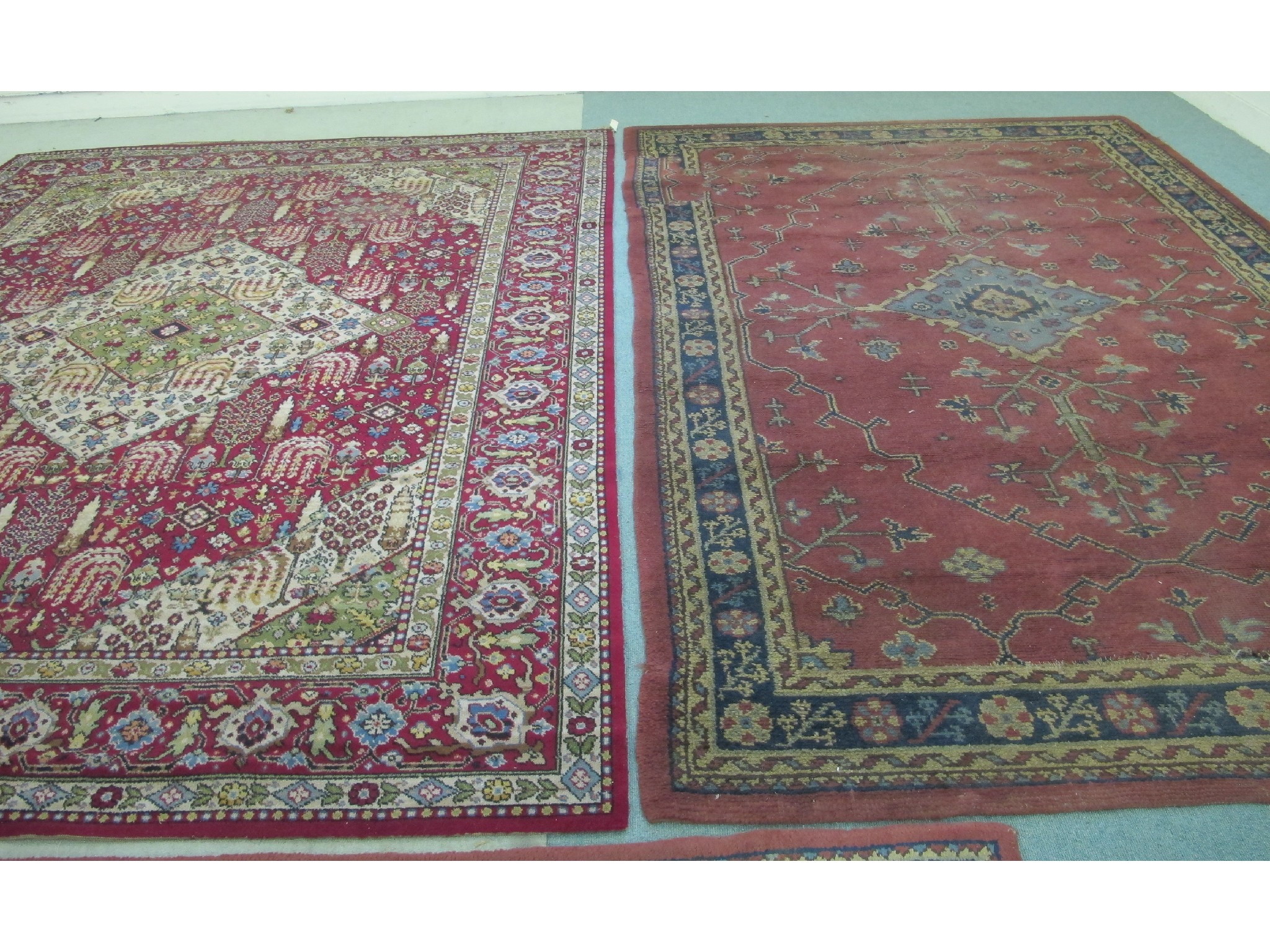 Appraisal: Two Persian style floral decorated carpets on red grounds x