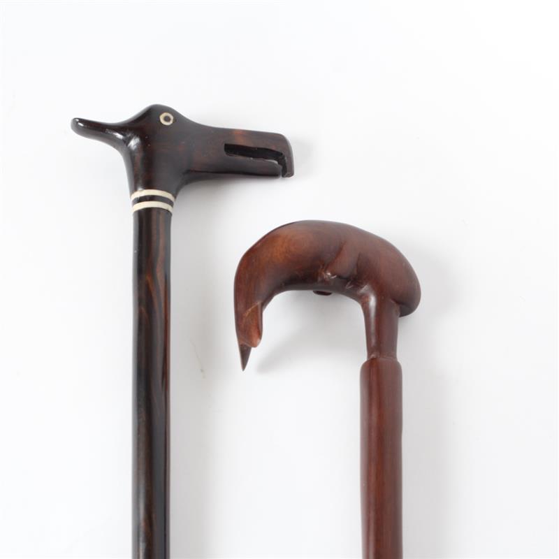 Appraisal: Two carved wood walking canes with decorative animal figural handles