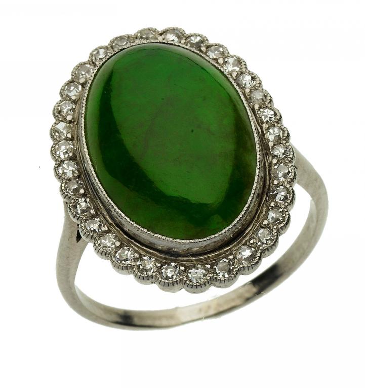 Appraisal: A DIAMOND AND NEPHRITE CLUSTER RING the oval cabochon in