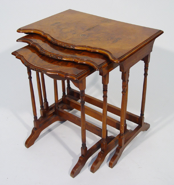 Appraisal: Nest of three walnut occasional tables with carved serpentine fronts