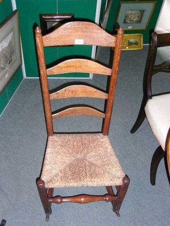 Appraisal: A TH CENTURY LADDERBACK ROCKING CHAIR with rush seat