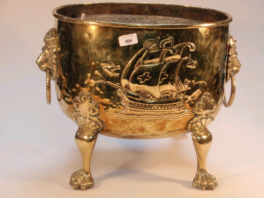 Appraisal: An embossed oval brass log box with lion mask handles