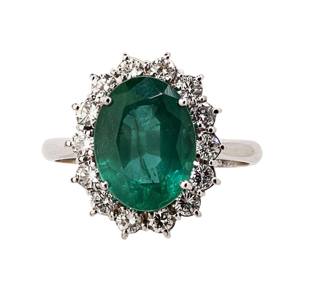 Appraisal: An emerald and diamond cluster ring the oval cut emerald