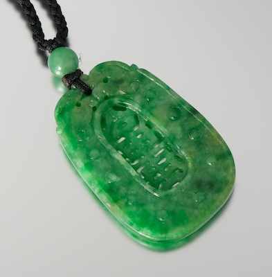 Appraisal: A Carved Green Jade Pendant on Cord Carved jade pendant