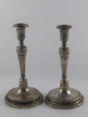 Appraisal: A pair of hand raised silver candlesticks the circular bases