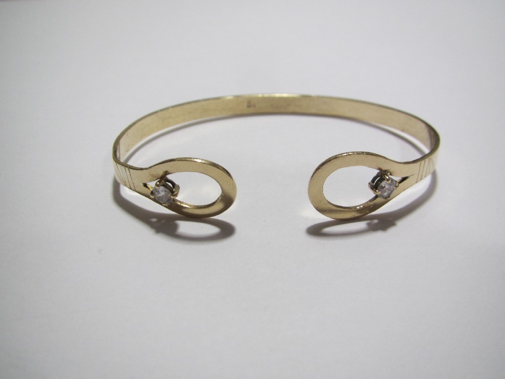 Appraisal: A ct gold bangle the openwork terminals set with zirconium