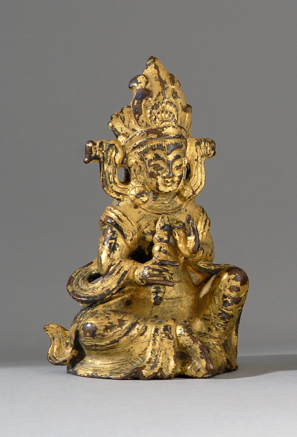 Appraisal: GILT-BRONZE FIGURE OF A DEITY th CenturySeated and holding a