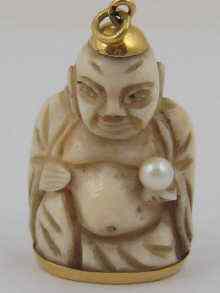 Appraisal: A carved ivory figure a pearl in his hand with