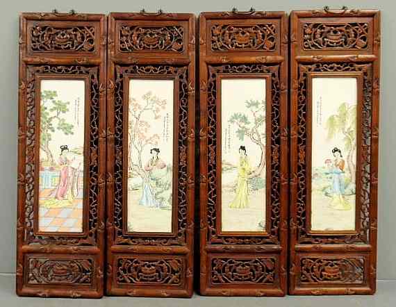 Appraisal: Four Asian carved exotic wood panels with painted porcelain inserts