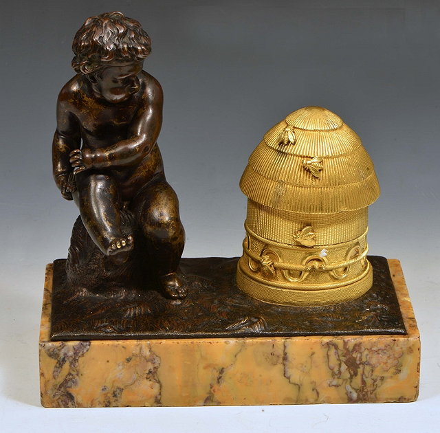 Appraisal: A CONTINENTAL BRONZE of child seating next to a gilded