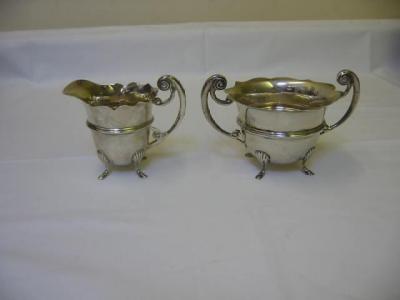 Appraisal: AN EDWARDIAN CREAM JUG AND SUGAR BOWL the jug with