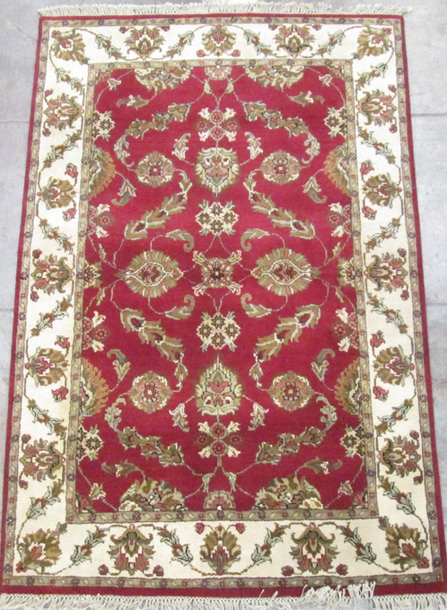 Appraisal: HAND KNOTTED ORIENTAL AREA RUG Indo-Persian floral design on madder