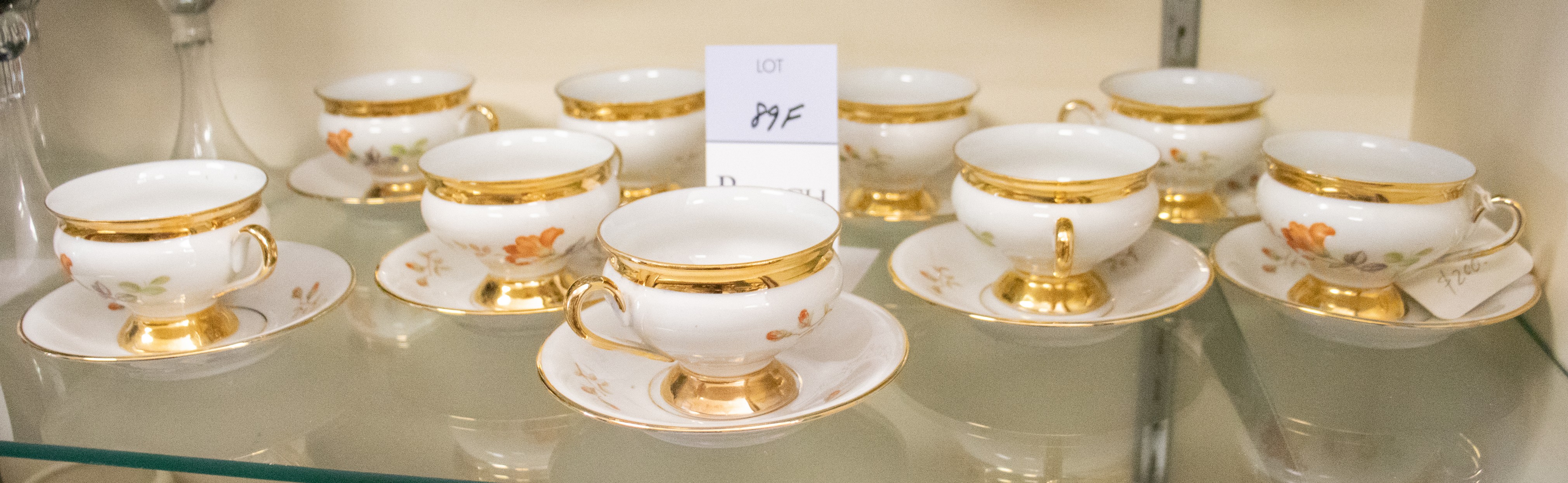 Appraisal: Porcelain footed demitasse cups saucers peach flowers with gilt trim