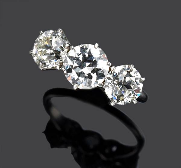 Appraisal: A diamond three stone ring centering a transitional-cut diamond flanked