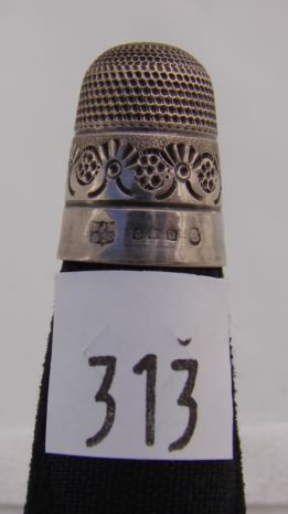 Appraisal: Silver tone thimble with ornate design above band