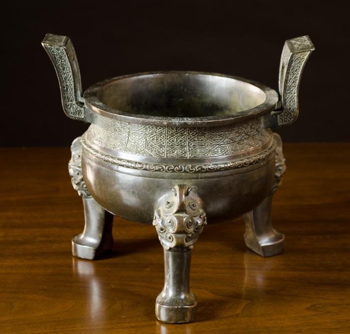 Appraisal: CHINESE BRONZE CENSER tri-footed with raised split handles Height inches