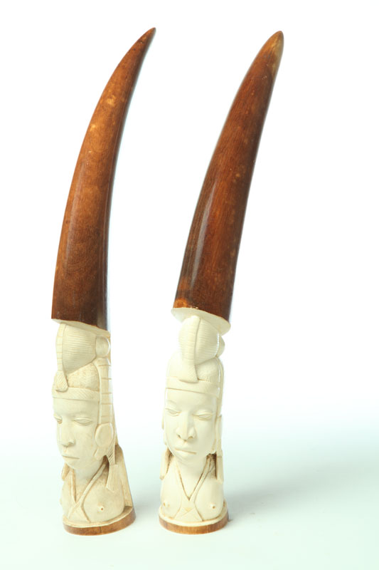 Appraisal: PAIR OF IVORY CARVINGS Africa early th century Stained tusks